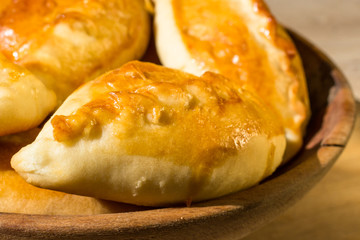 Baked cakes. Yeast baking. Pies with meat, cabbage and mushrooms. Homemade food. Slavic cuisine. Delicious pastries. Ruddy snack. Flour product. Bake in the oven. Junk food.