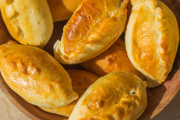 Baked cakes. Yeast baking. Pies with meat, cabbage and mushrooms. Homemade food. Slavic cuisine. Delicious pastries. Ruddy snack. Flour product. Bake in the oven. Junk food.