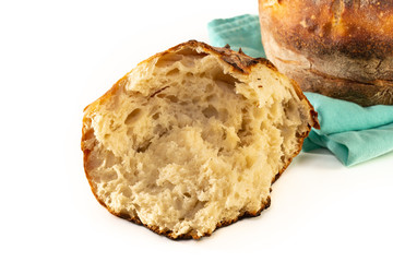 A homemade baked loaf of round artisan white sourdough bread isolated on white.