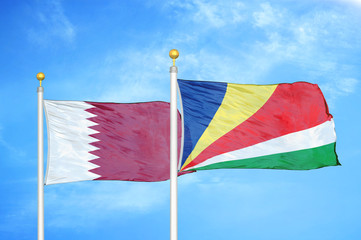 Qatar and Seychelles two flags on flagpoles and blue cloudy sky
