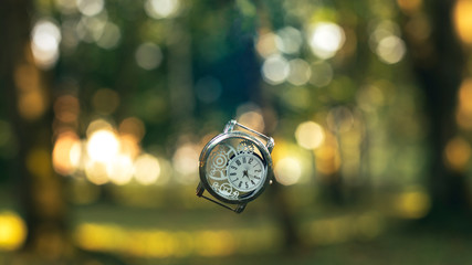 outgoing not limited time concept picture vintage clock falling down on blurred abstract colorful nature background