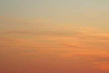 Sun below the horizon and clouds in the fiery dramatic orange sky at sunset or dawn backlit by the sun. Place for text and design.