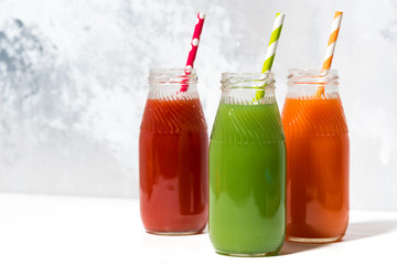 variety of fresh juices in bottles on white background
