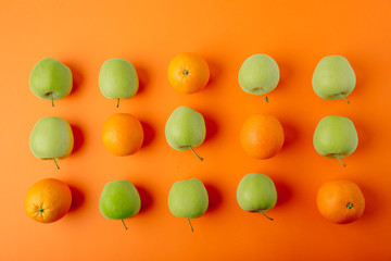 juicy fresh ripe oranges and apples on an orange background