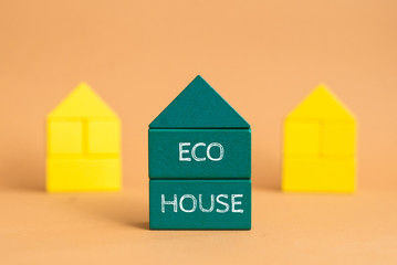 Eco friendly house - small toy model house with word ECO HOUSE on kraft cartboard bacground