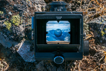 look at the mountain scenery through the viewfinder of an old camera