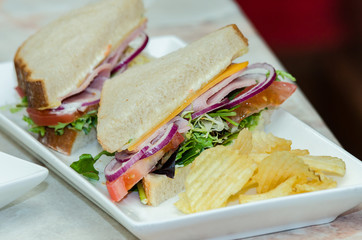 A selection of various sandwiches and fillings, garnished with crisps and salad.