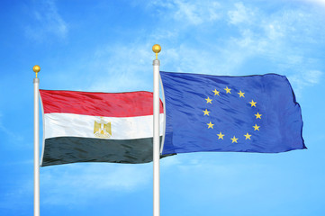 Egypt and European Union two flags on flagpoles and blue cloudy sky