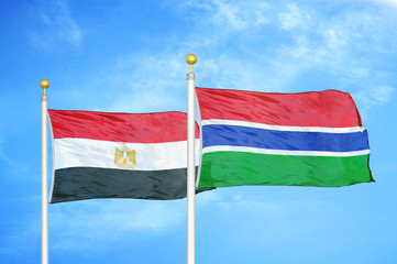 Egypt and Gambia two flags on flagpoles and blue cloudy sky