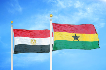 Egypt and Ghana two flags on flagpoles and blue cloudy sky