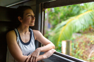 Train ride in Sri Lanka. Woman sitting and looking out the window