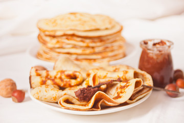 homemade russian thin tasty pancakes on the plate with chocolate cream sauce.