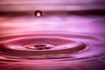 hintergrund in lila und rot mit welle und wasser tropfen im wasser