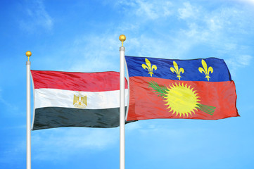 Egypt and Guadeloupe two flags on flagpoles and blue cloudy sky