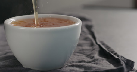 pour black tea in white cup closeup with copy space