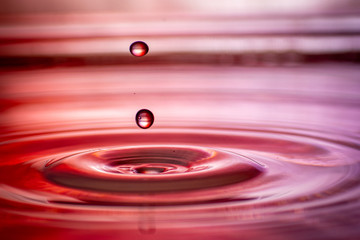 hintergrund in lila und rot mit welle und wasser tropfen im wasser