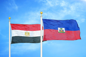 Egypt and Haiti two flags on flagpoles and blue cloudy sky