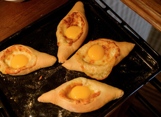 Ready khachapuri on a baking sheet. Top view