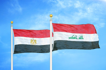 Egypt and Iraq two flags on flagpoles and blue cloudy sky