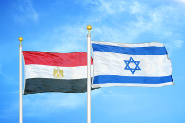 Egypt and Israel two flags on flagpoles and blue cloudy sky