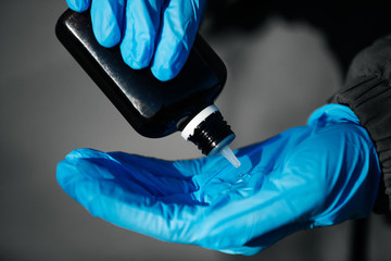 Antiseptic in a bottle on medical gloves
