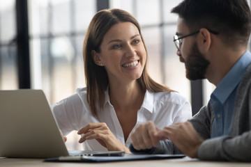 Close up happy smiling businesswoman listening businessman talking in boardroom at meeting. Leader presenting new business concept for colleague discuss. Team together using laptop for teamwork.