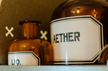 Bottles, including aether (ether) anaesthetic on shelves within a doctor's surgery from WW1.