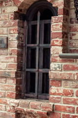 Old brick wall with brick filled window.