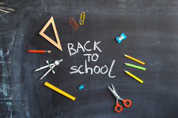 Fototapeta na wymiar Back to school on black chalk board background. Tools for education. Banner with handmade lettering. 