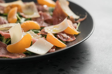 Salad with prosciutto, tangerines and vintage cheese with copy space