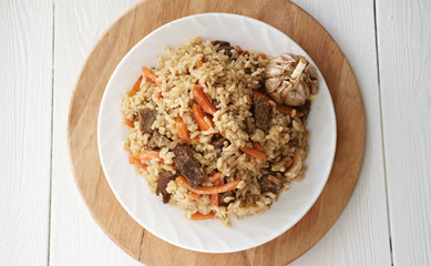 pilaf- spicy delicious traditional asian dish made of rice, vegetables and meat in a plate. Top view. 