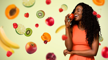 Healthy diet. Beautiful African American woman eating apple, collage with flying fruits. Copy space. Panorama