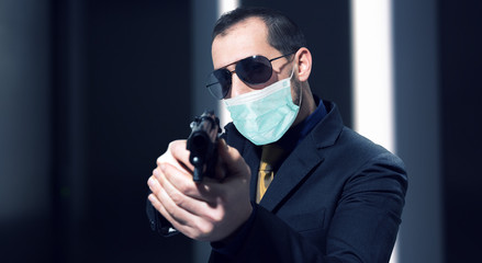 Secret agent holding a gun while wearing a mask