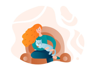 Girl with a cat in her arms on a home armchair