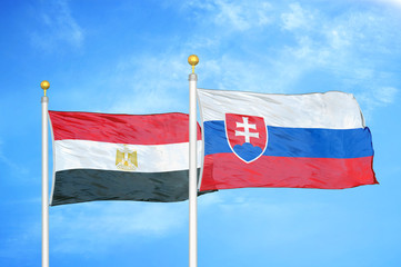 Egypt and Slovakia two flags on flagpoles and blue cloudy sky