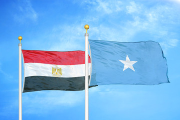 Egypt and Somalia two flags on flagpoles and blue cloudy sky
