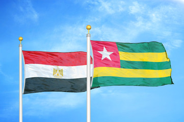 Egypt and Togo two flags on flagpoles and blue cloudy sky