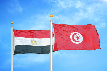 Egypt and Tunisia two flags on flagpoles and blue cloudy sky