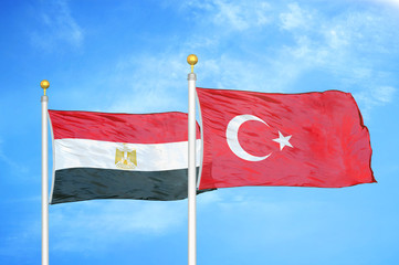 Egypt and Turkey two flags on flagpoles and blue cloudy sky