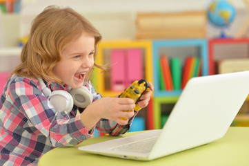 Close up portrait of little girl playing computer game