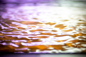 Fototapeta na wymiar hintergrund in lila und rot mit welle und wasser tropfen im wasser