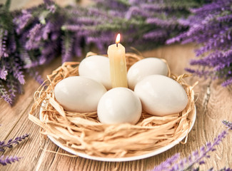 White Easter eggs with lighting candle. Happy Easter Concept. Congratulations Easter card.