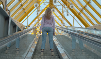 Young woman standing on the escalator