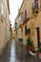 Fototapeta na wymiar Narrow street in the walled city of Mdina, Malta, in heavy rain.