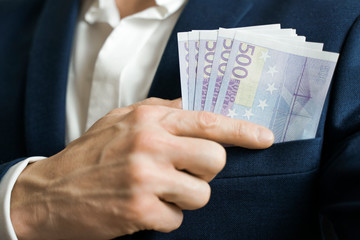 Money success concept. 500 euro bills in businessman jacket pocket. Symbol of success and wealth.