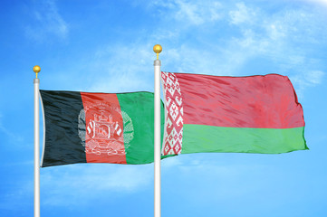 Afghanistan and Belarus   two flags on flagpoles and blue cloudy sky