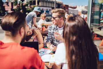 Young man explaining homework to friends