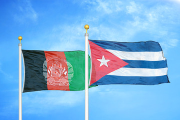Afghanistan and Cuba  two flags on flagpoles and blue cloudy sky