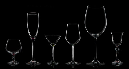 Five glass goblets on a black background