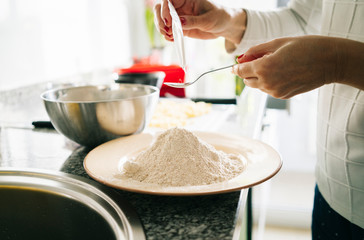 A woman prepares the ingredients to make a sponge cake in her home kitchen